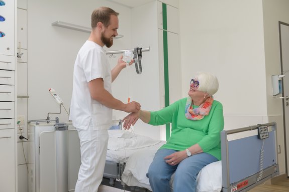 Pfleger mit Patientin in der Geriatrie
