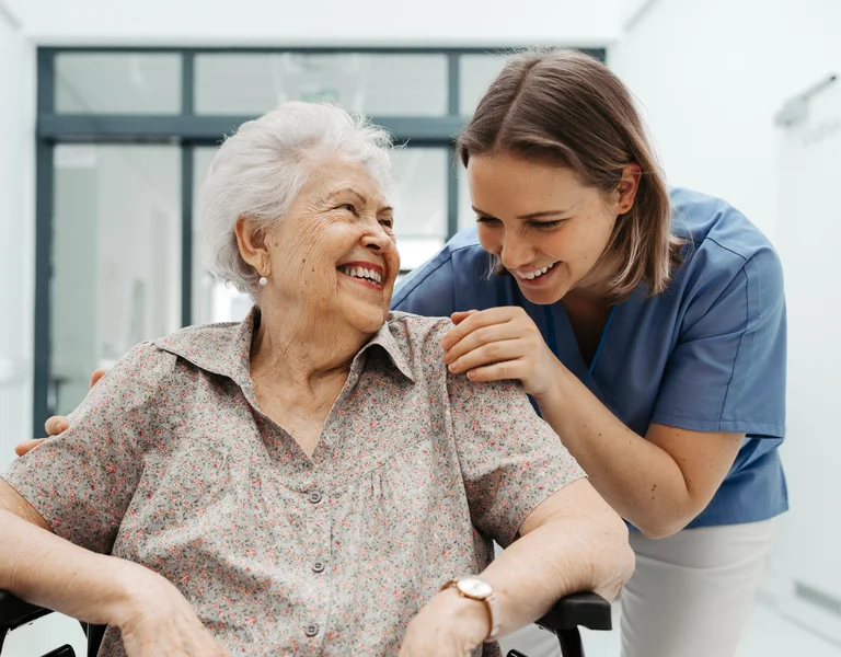 Pflegerin mit Seniorin im Rollstuhl
