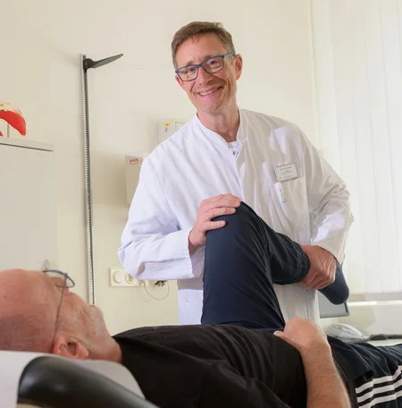 Arzt untersucht das Knie eines Patienten